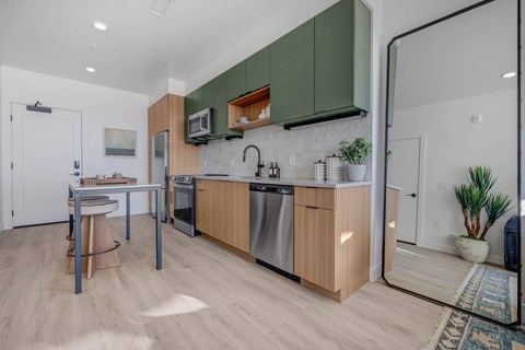 A kitchen with wooden cabinets and a white brick backsplash.