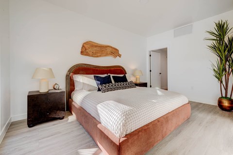 A bedroom with a large bed and a wooden headboard.