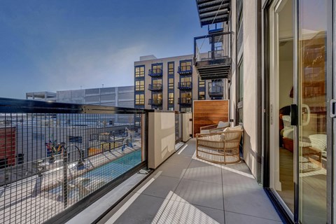 A balcony with a pool and a chair.