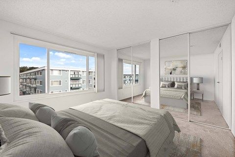 A bedroom with a large bed and a view of a building outside the window.