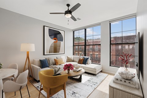 A living room with a yellow chair and a white couch.
