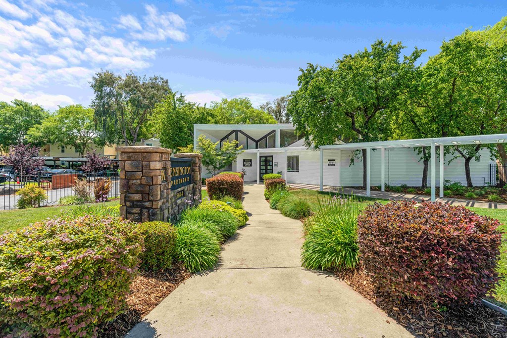 a house with a path in front of it and trees in the background