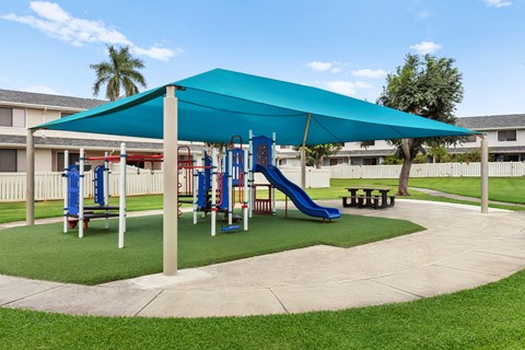 play area with sides and jungle gym. Covered to provide shade. grass surrounding,
