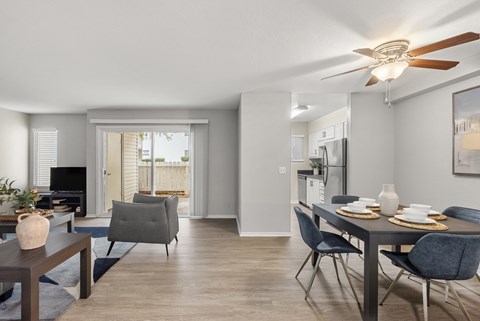 A modern dining room with a table set for two and a television in the corner.