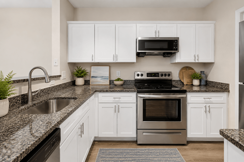 A kitchen with white cabinets and a black stove top oven.