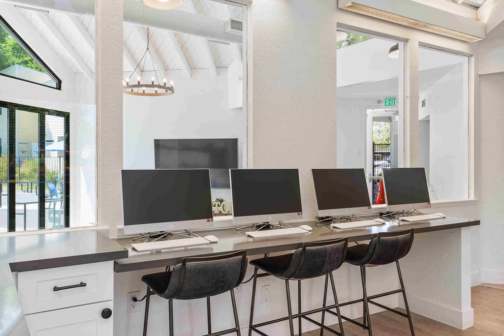 a row of computer monitors sitting on top of a desk