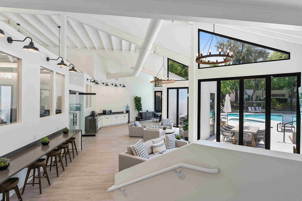 a large open living room with a pool in the background