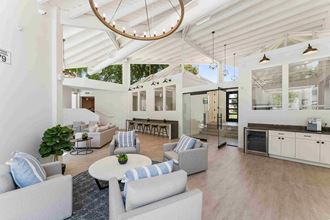 a large open living room with white walls and a vaulted ceiling with exposed beams - Photo Gallery