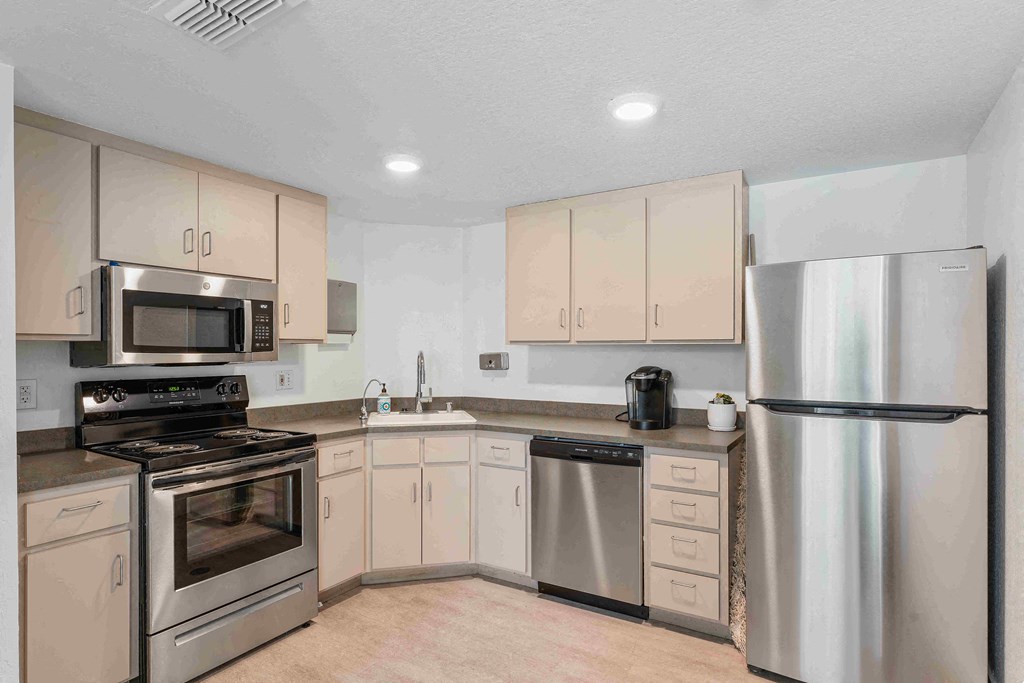a kitchen with white cabinets and stainless steel appliances