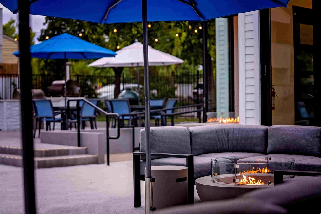 a patio with couches and tables and umbrellas