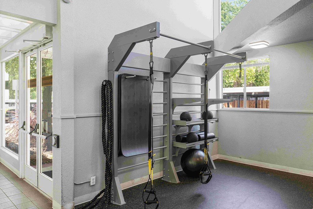 a bunk bed with a ladder and weights in the corner of a room