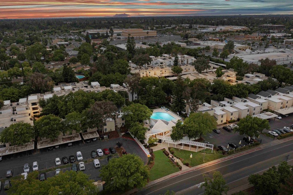 an aerial view of a city with a blue pool in the middle of a parking lot