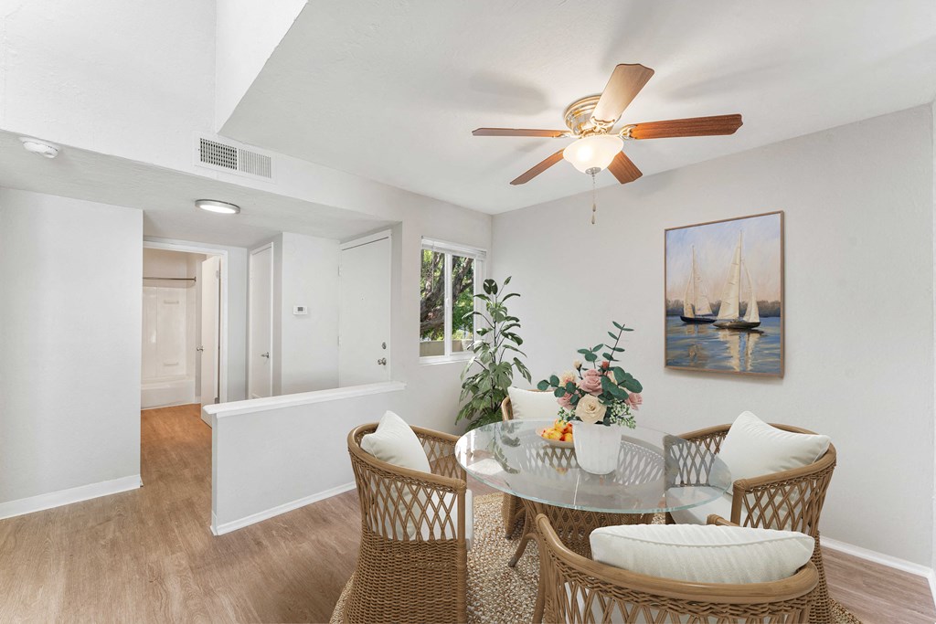 a dining room with a glass table and rattan chairs