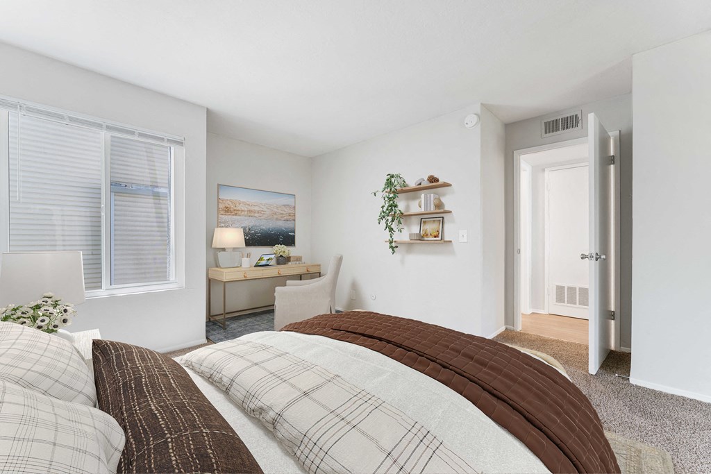 a bedroom with a large bed and a desk with a chair