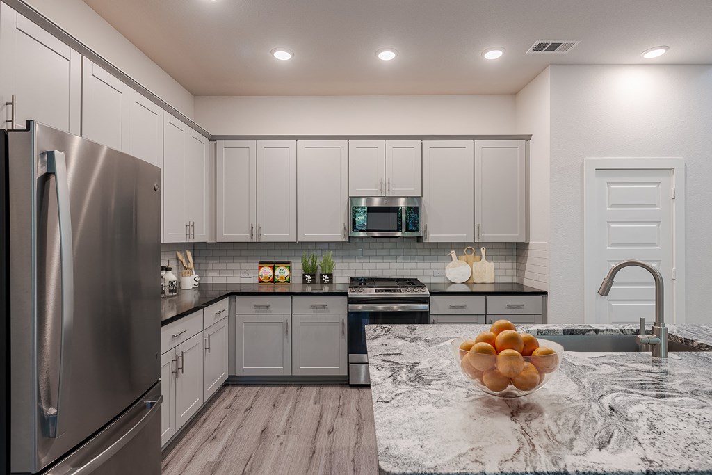 a kitchen with stainless steel appliances and marble counter tops