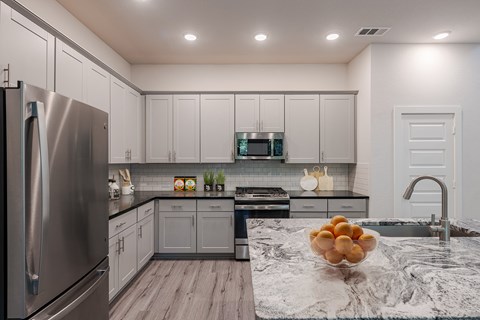 a kitchen with stainless steel appliances and marble counter tops
