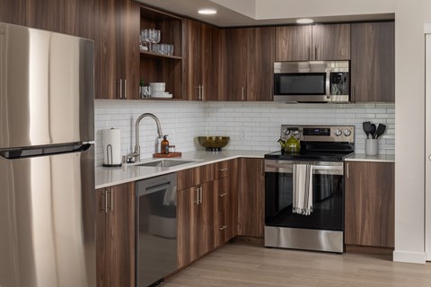 A modern kitchen with wooden cabinets and stainless steel appliances.