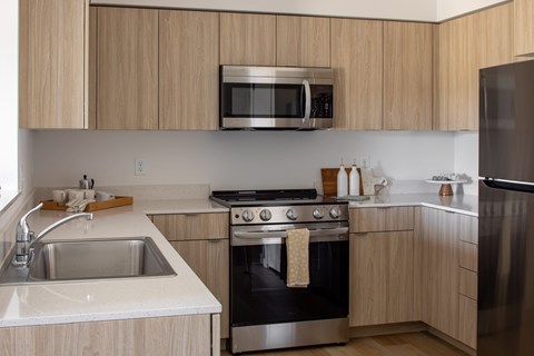 Modern kitchen with wooden cabinets and stainless steel appliances at The Arvon, Vancouver, 98662