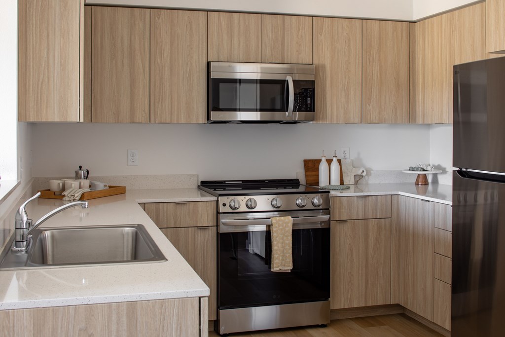 A modern kitchen with wooden cabinets and stainless steel appliances.