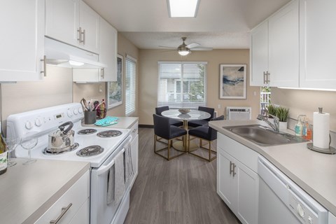 A kitchen with white cabinets and a white stove top oven.