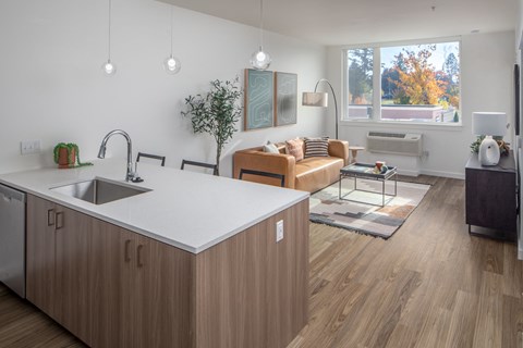 a kitchen island in a living room with a couch and a window