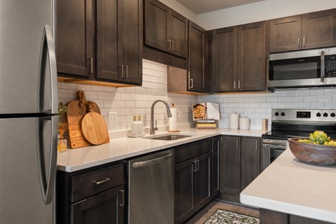 A kitchen with black cabinets and a white countertop.