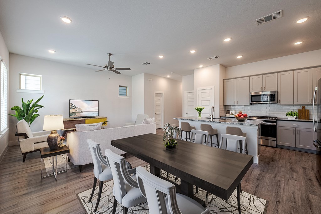 a living room and dining room with a table and chairs