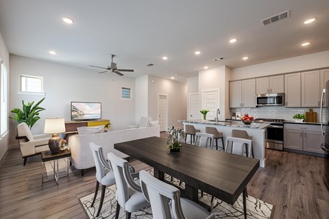 a living room and dining room with a table and chairs