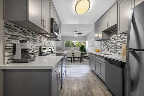 A modern kitchen with a dining table and chairs in the middle.