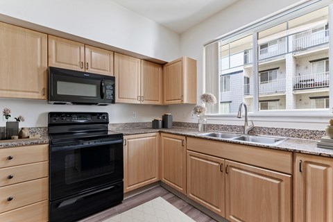 A kitchen with wooden cabinets and black appliances.