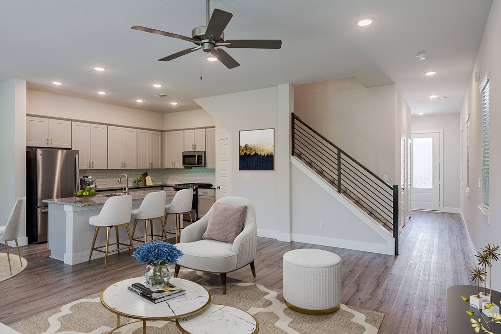 an open living room and kitchen with a spiral staircase