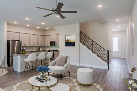 an open living room and kitchen with a spiral staircase