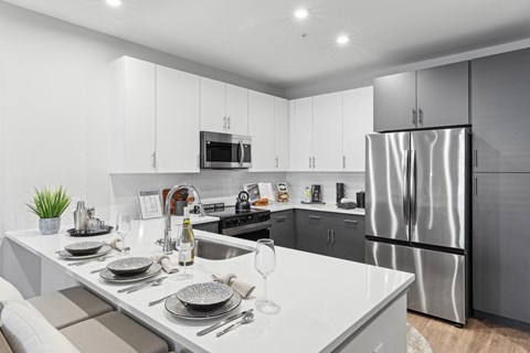 A modern kitchen with a dining table set for two.