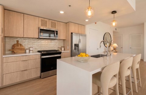 A modern kitchen with a white island and wooden cabinets.
