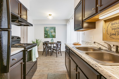 A kitchen with a table and chairs in the middle of it.