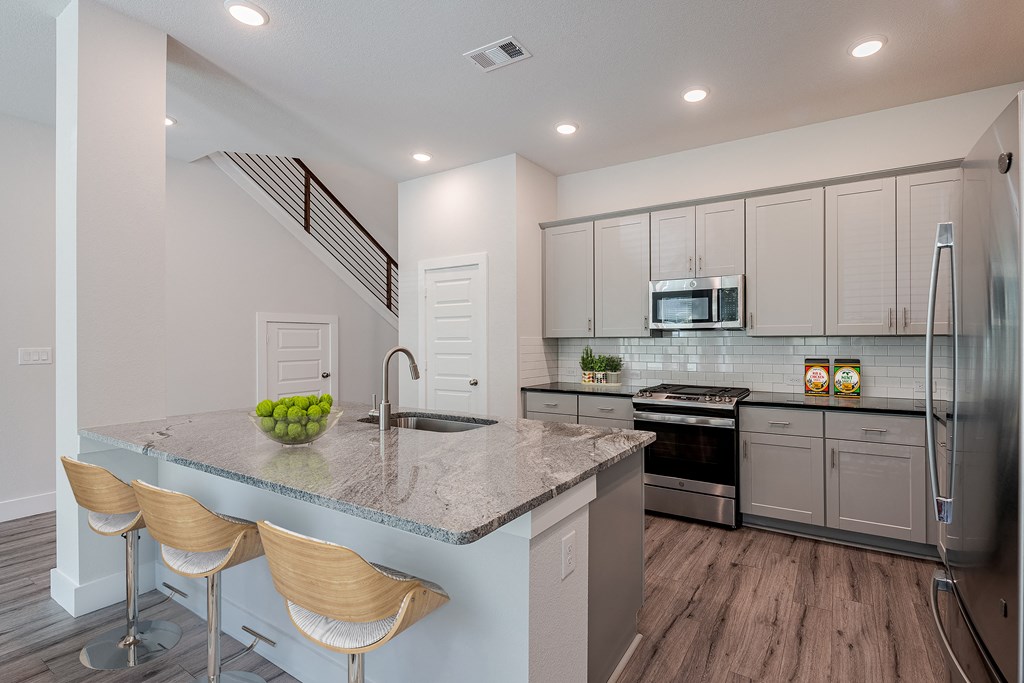 a kitchen with a marble counter top and stainless steel appliances