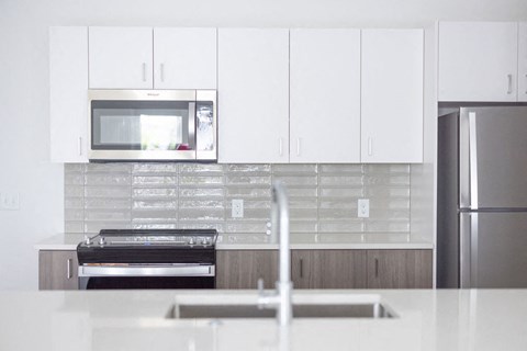 a kitchen with white cabinets and a stove and a microwave