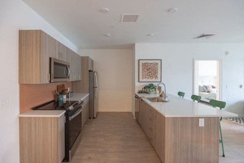 a kitchen with an island and a stove and a refrigerator