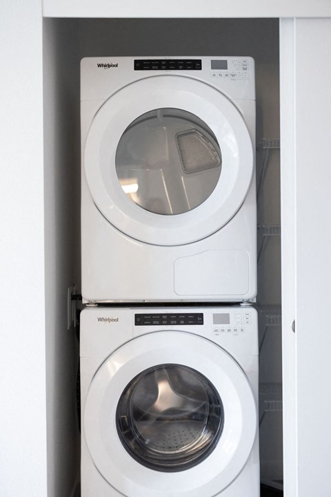 a white washer and dryer in a white closet