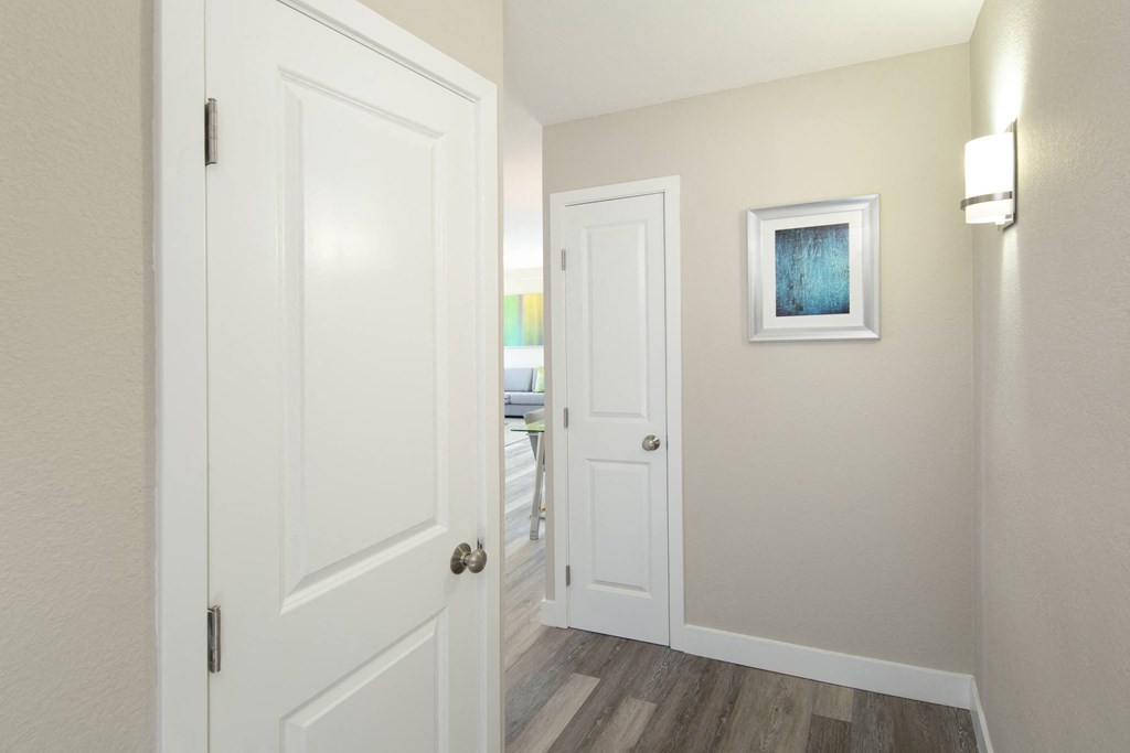a hallway with two doors and a painting on the wall
