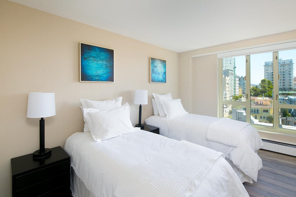 a bedroom with two beds and a large window