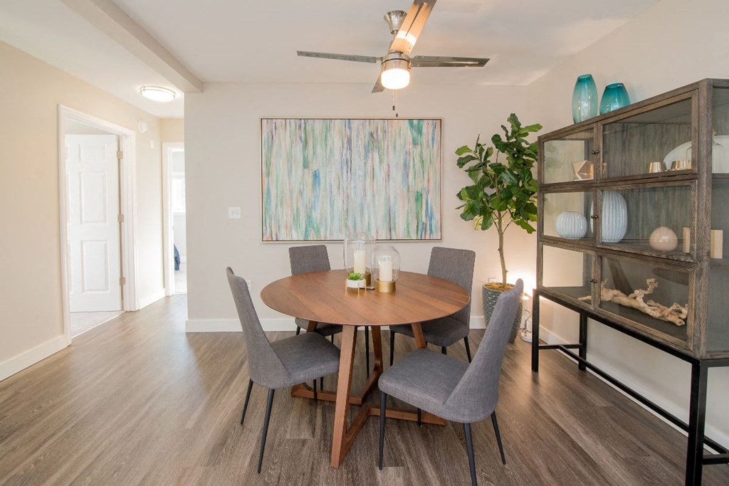 a dining room with a wooden table and gray chairs at The Arden Apartments, Gresham, OR