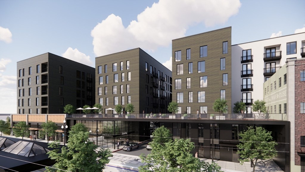 a rendering of an apartment building with a pedestrian bridge