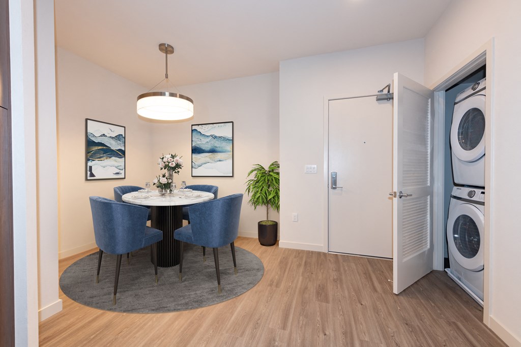 a dining area with a table and chairs and a washer and dryer