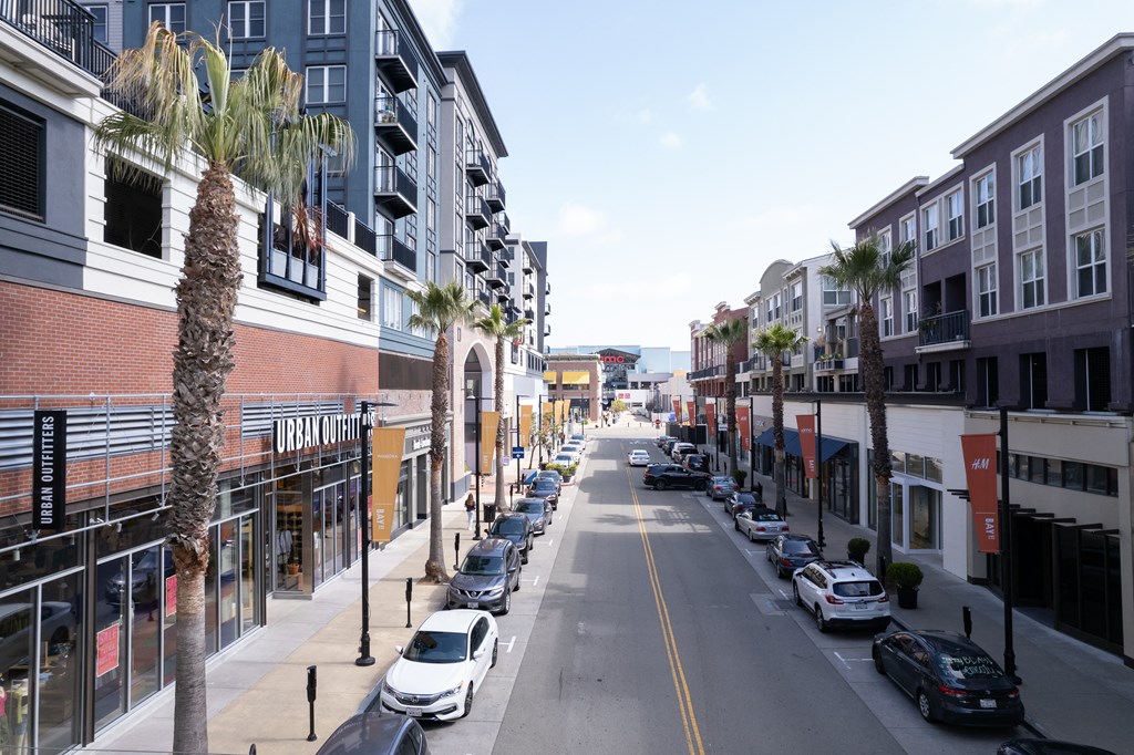 a city street with palm trees and buildings on either side