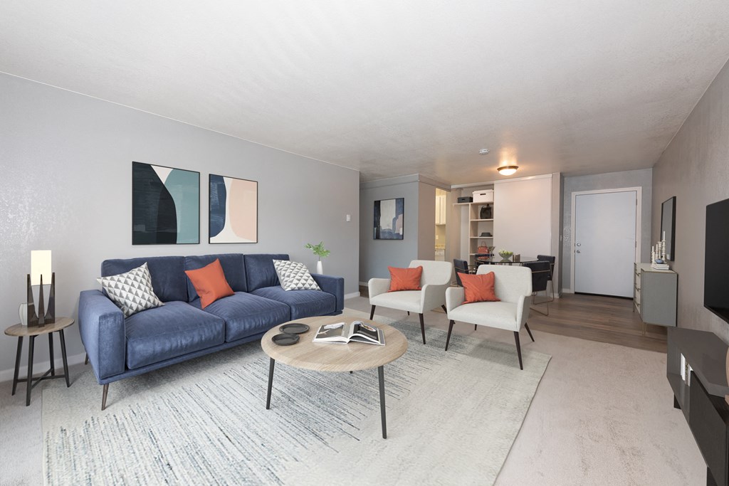 a living room with a blue couch and two white chairs