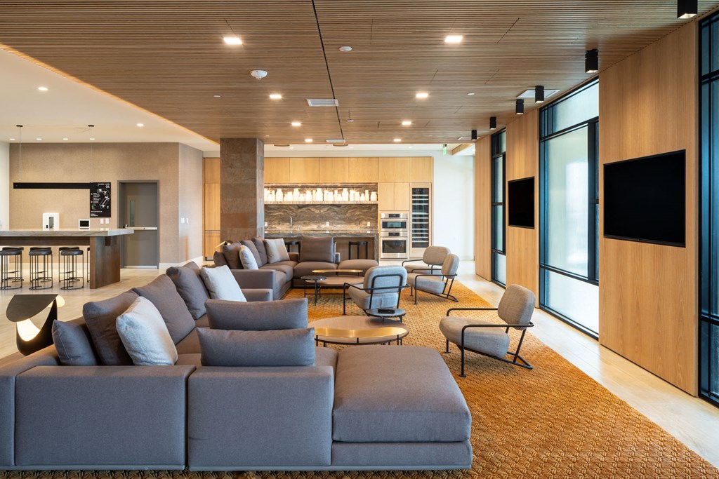 clubroom with a couch and chairs in front of a kitchen