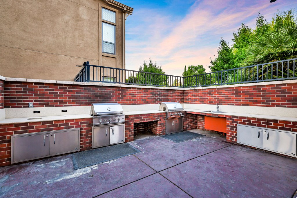 a patio with three stainless steel appliances and a brick wall