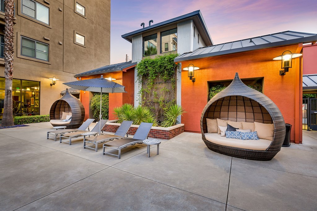 an outdoor patio with chairs and a hammock