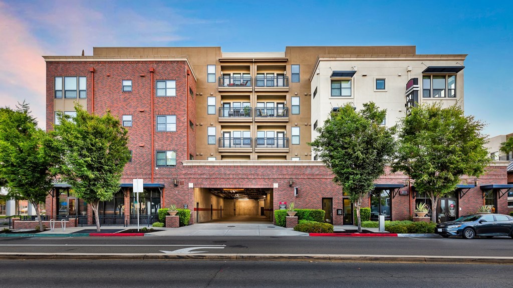 a large red brick apartment building with a driveway